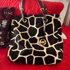 Michael Kors tote, giraffe print, cloth with adjustable leather straps . Pockets